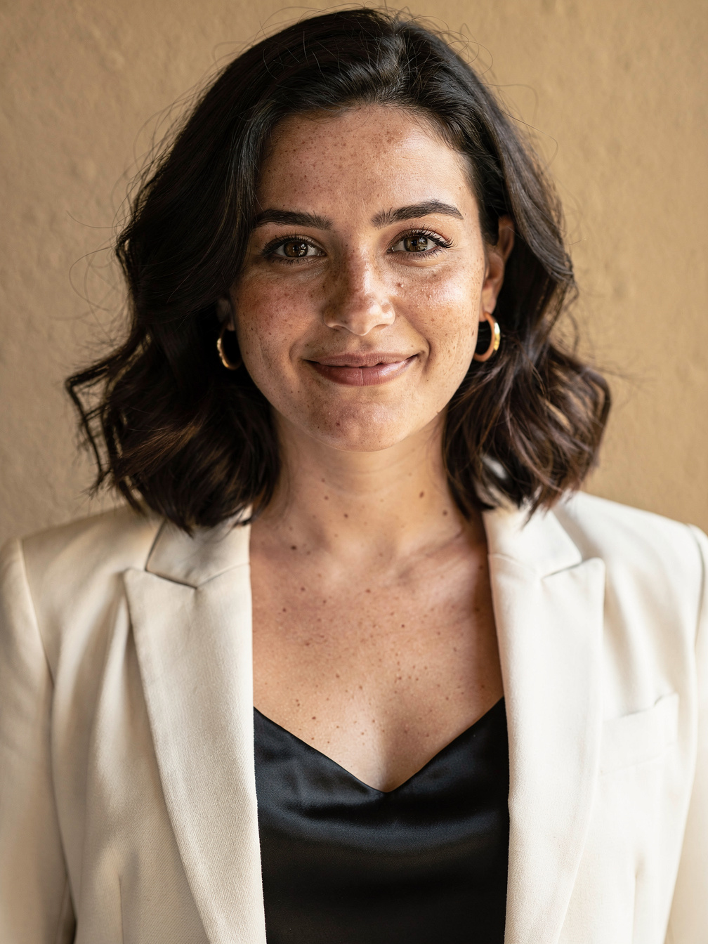 The fictional adult woman in the sample: a clear, front-facing portrait in a cream blazer.